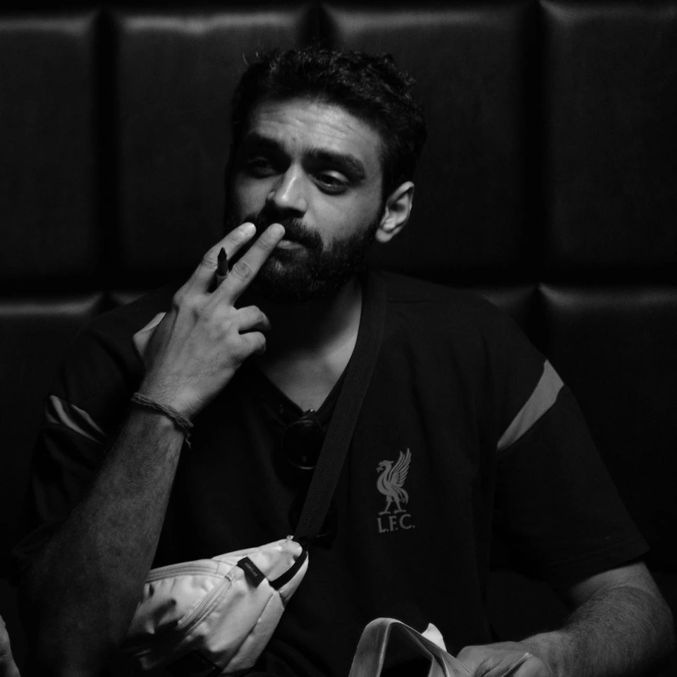 Black-and-white portrait of Ravi Prakash seated with a pen in hand